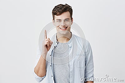 Satisfied and pleased caucasian customer pointing with index finger up at blank space over head for your advertisment Stock Photo