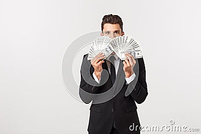 Portrait of a satisfied young businessman holding bunch of money banknotes isolated over white background. Stock Photo