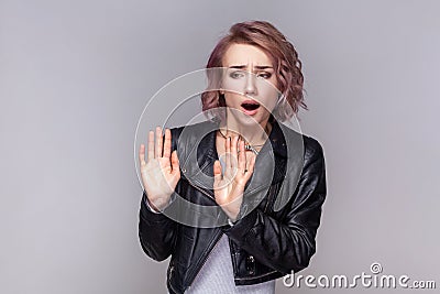 Scared frighten shocked woman standing with showing stop sign, asking to stop. Stock Photo