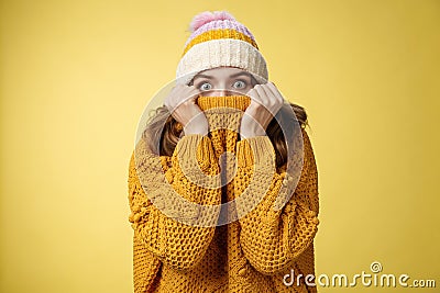 Portrait scared insecure timid cute girl hiding face pull sweater nose widen eyes afraid stunned standing stupor yellow Stock Photo