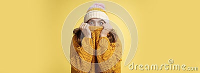 Portrait scared insecure timid cute girl hiding face pull sweater nose widen eyes afraid stunned standing stupor yellow Stock Photo