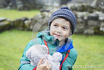 Portrait of School kid taking teddy bear explore with his learning history, Happy child boy wearing warm cloths holding his soft Stock Photo