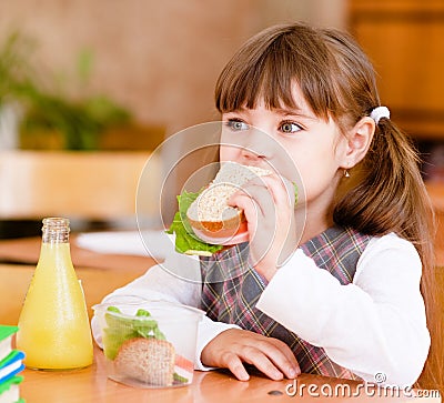 Portrait schoolgirl while having lunch during Stock Photo