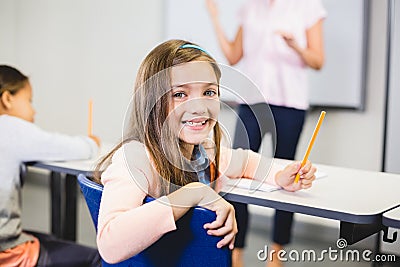 Portrait of schoolgirl smiling in classroom Stock Photo