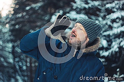 Portrait of screaming bearded man traveler forester hunter in winter forest Stock Photo