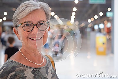 Portrait of senior attractive woman enjoying shopping in a mall, smiling looking at camera. Happy gray haired people Stock Photo