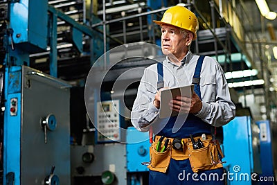 Senior Factory Worker Using Tablet Stock Photo