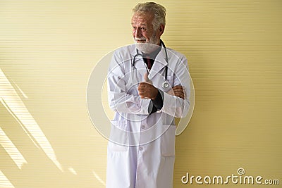 Portrait of senior doctor standing and showing thumb up at hospital,Happy and smiling positive thinking attitude,Copy space for te Stock Photo