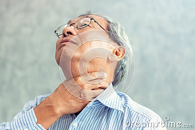 Portrait of senior man touching his neck and having throat irritation Stock Photo