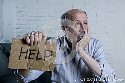 Portrait of senior mature old man on his 60s at home couch alone feeling sad and worried suffering pain and depression Stock Photo