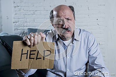 Portrait of senior mature old man on his 60s at home couch alone feeling sad and worried suffering pain and depression Stock Photo