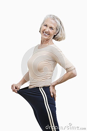 Portrait of senior woman in oversized pants against white background Stock Photo