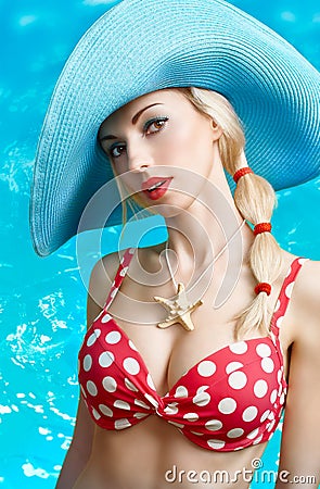 Beautiful woman in red polka dots fashionable swimsuit. PinUp Stock Photo