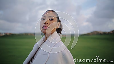 Portrait serene african american woman looking camera at green meadow view. Stock Photo