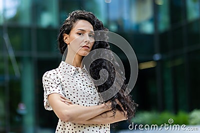 Portrait of serious confident hispanic woman outside office building, businesswoman looking thoughtfully at camera with Stock Photo