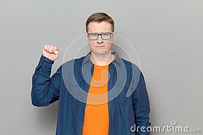 Portrait of serious rebellious mature man raising clenched fist up Stock Photo