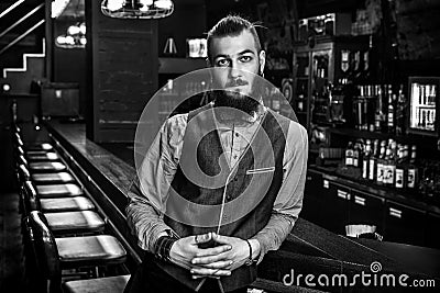 Serious young bartender in his bar. Black and white photo Stock Photo