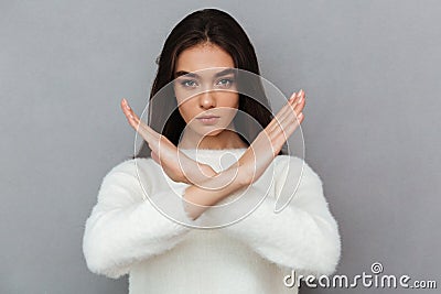 Portrait of a serious young woman showing crossed hands gesture Stock Photo