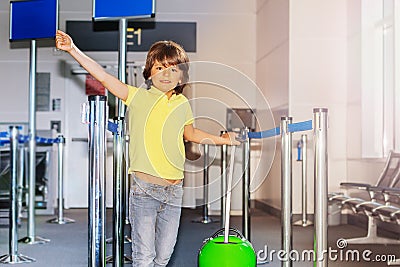 Cute boy with suitcase ahead of the departure gate Stock Photo
