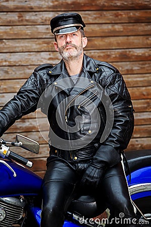 Sexy biker dressed in black leather sitting on his bike Stock Photo