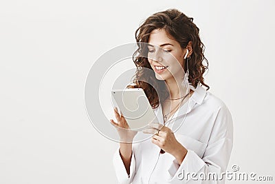 Portrait of confident caucasian woman with stylish haircut browsing in tablet with broad smile and expressing Stock Photo