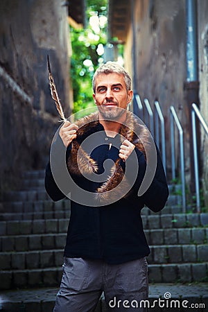 Portrait of a man and wolf furry and eagle feathers. Stock Photo