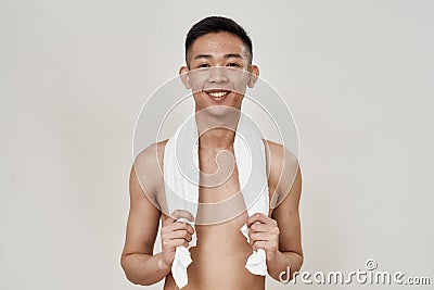 Portrait of shirtless young asian man with problematic skin and hyperpigmentation on his face posing with towel around Stock Photo