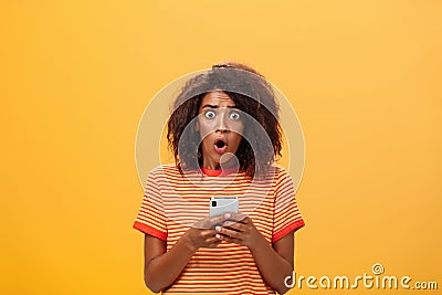 Portrait of shocked and concerned stunned dark-skinned woman with afro hairstyle popping eyes from concern and panic Stock Photo