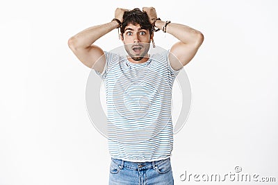 Portrait of shocked guy in stupor dropping jaw astomished pulling hair out of head being impressed deeply standing Stock Photo