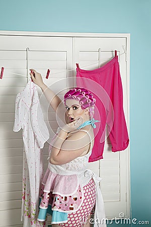 Portrait of a shocked plus-size woman drying clothes Stock Photo