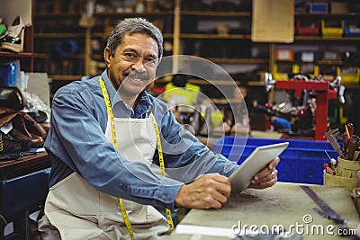 Portrait of shoemaker using digital tablet Stock Photo