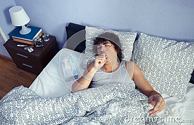 Portrait of sick man coughing lying on bed Stock Photo