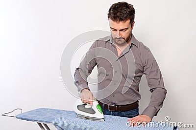 Portrait of single man ironing a shirt Stock Photo