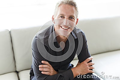 Portrait of single 40s man sitting in sofa Stock Photo