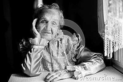 Portrait of a Slavic grandmother at the table in the house. Stock Photo