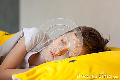 Portrait Sleeping child on soft light background. Little boy sleeping in yellow bed Stock Photo