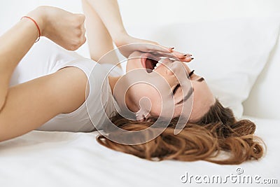 Portrait of a sleepy young woman laying in bed Stock Photo