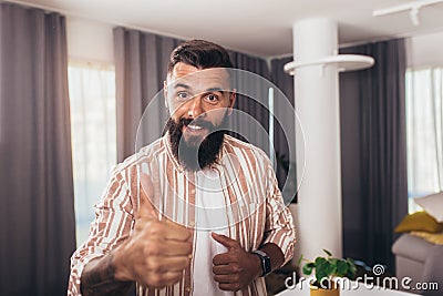 Smart confident smiling millennial man standing at home Stock Photo