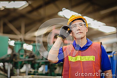Portrait of smart engineer Asian Chinese happy labor worker handsome model in heavy industry background.hand at protection Stock Photo