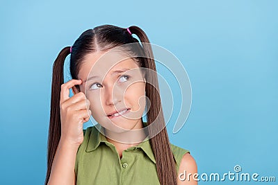 Portrait of smart minded kid finger temple bite lip look empty space decision isolated on blue color background Stock Photo