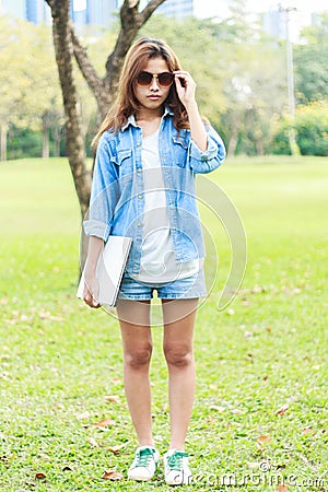 Portrait smart women with jeans shirt hold laptop computer, fashion outdoor Stock Photo