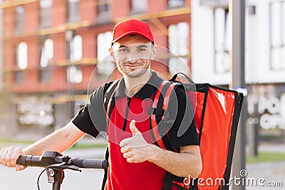 Portrait smiling american man courier food delivery standing with thermal backpack, electric scooter looking at camera Stock Photo