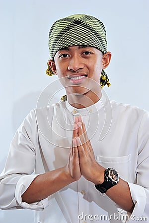 Portrait of smiling asian muslim man welcoming you Stock Photo