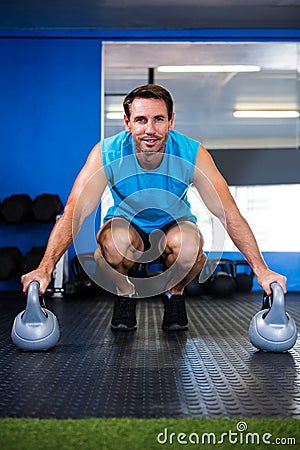 Portrait of smiling athlete with kettlebell in gym Stock Photo