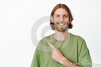 Portrait of smiling blond guy pointing finger at upper left corner, looking confident, showing advertisement sale banner Stock Photo