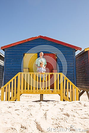 Portrait of smiling boy with grandfather standing at beach hut Stock Photo