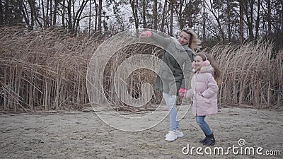 Portrait of smiling Caucasian woman holding hand at forehead and talking to her daughter. Cheerful girl jumping and. Holding mother`s hand. Family waiting for stock video footage Portrait of smiling Caucasian woman holding hand at forehead and talking to her daughter. Cheerful girl jumping and. Holding mother`s hand. Family waiting for stock video footage