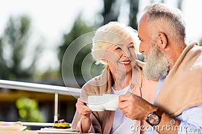 portrait of smiling elderly couple with cups of coffee looking Stock Photo