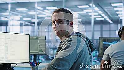 Portrait of smiling engineer inspecting server rows in data center Stock Photo
