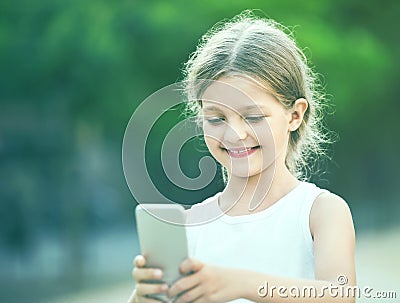 Portrait of smiling girl playing with mobile phone Stock Photo